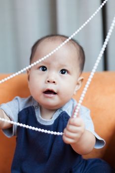 Baby boy.child Asian., And played on the orange sofa.