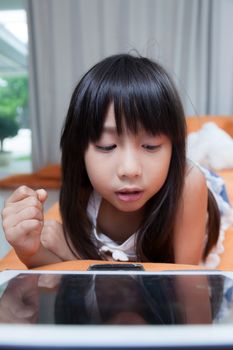 Girl playing with tablet. girl with long black hair.