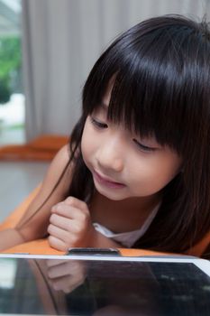 Girl playing with tablet. girl with long black hair.