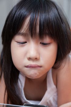 Girl playing with tablet. girl with long black hair.