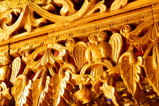 the detail of ancient thai decorated pattern that include handcraft wood carving work,gold painting and decorated with gold plate,mirror and precious stone,Lampang temple,Thailand