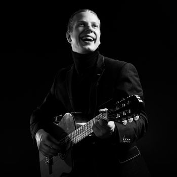 Music. Musician in black suit with a guitar