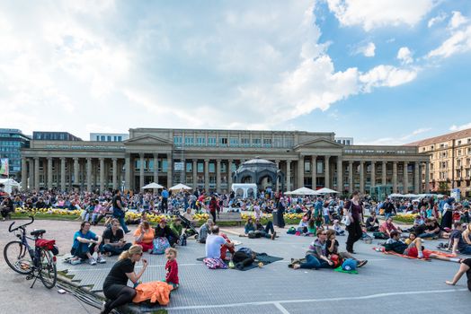 STUTTGART, GERMANY - APRIL 24, 2014: People are enjoying the open air cinema in the city center of Stuttgart on a sunny spring day during the 21st International Trickfilm Festival on April, 26,2014 in Stuttgart, Germany. Besides a special conference and movie competition, the makers are involving the broad audience through a public screening of movies and games competitions.