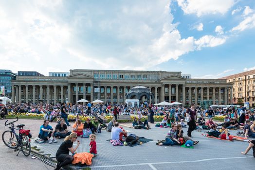 STUTTGART, GERMANY - APRIL 24, 2014: People are enjoying the open air cinema in the city center of Stuttgart on a sunny spring day during the 21st International Trickfilm Festival on April, 26,2014 in Stuttgart, Germany. Besides a special conference and movie competition, the makers are involving the broad audience through a public screening of movies and games competitions.