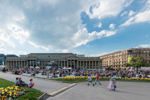 STUTTGART, GERMANY - APRIL 24, 2014: People are enjoying the open air cinema in the city center of Stuttgart on a sunny spring day during the 21st International Trickfilm Festival on April, 26,2014 in Stuttgart, Germany. Besides a special conference and movie competition, the makers are involving the broad audience through a public screening of movies and games competitions.