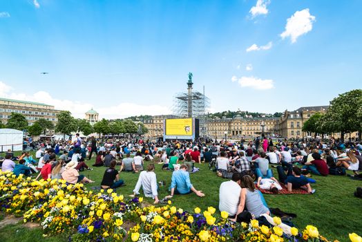 STUTTGART, GERMANY - APRIL 24, 2014: People are enjoying the open air cinema in the city center of Stuttgart on a sunny spring day during the 21st International Trickfilm Festival on April, 26,2014 in Stuttgart, Germany. Besides a special conference and movie competition, the makers are involving the broad audience through a public screening of movies and games competitions.