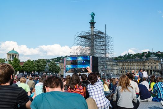 STUTTGART, GERMANY - APRIL 24, 2014: People are enjoying the open air cinema in the city center of Stuttgart on a sunny spring day during the 21st International Trickfilm Festival on April, 26,2014 in Stuttgart, Germany. Besides a special conference and movie competition, the makers are involving the broad audience through a public screening of movies and games competitions.