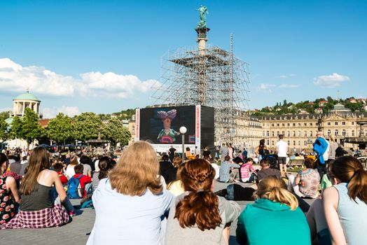 STUTTGART, GERMANY - APRIL 24, 2014: People are enjoying the open air cinema in the city center of Stuttgart on a sunny spring day during the 21st International Trickfilm Festival on April, 26,2014 in Stuttgart, Germany. Besides a special conference and movie competition, the makers are involving the broad audience through a public screening of movies and games competitions.