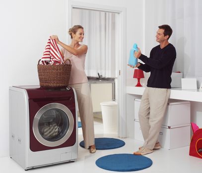 smiling woman with man dooing  laundry with washing machine 