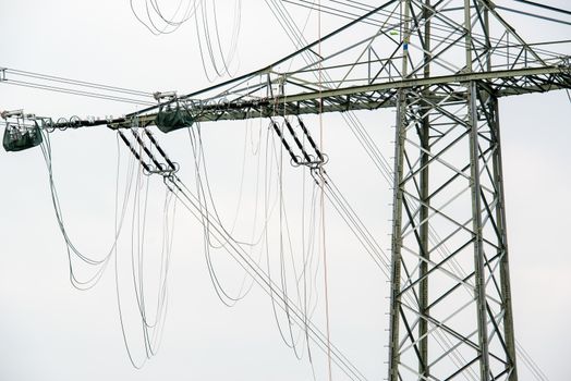 high voltage power pole construction works - cables being mounted