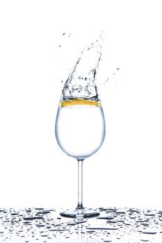 Lemon splashing into glass full of water on white background