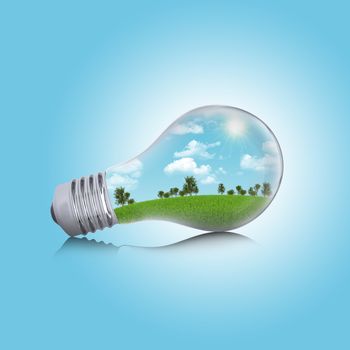 Trees, grass and sky in the light bulb. Concept of safe electricity