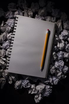 Graph paper notebook with pencil on dark background