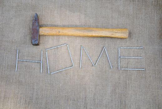 work hammer and stylized inscription of nails on linen texture