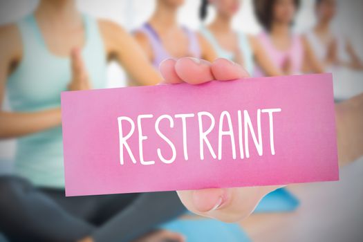 Woman holding pink card saying restraint against fitness class in gym