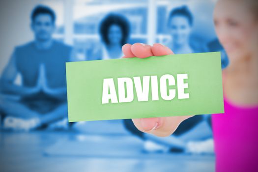 Fit blonde holding card saying advice against yoga class in gym