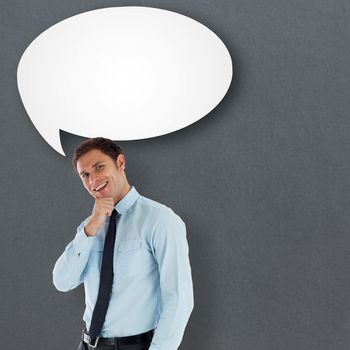 Thoughtful businessman with hand on chin against speech bubble