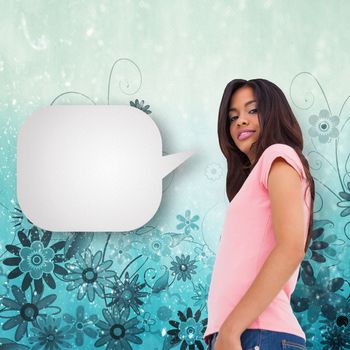 Pretty brunette stepping with speech bubble against digitally generated girly floral design