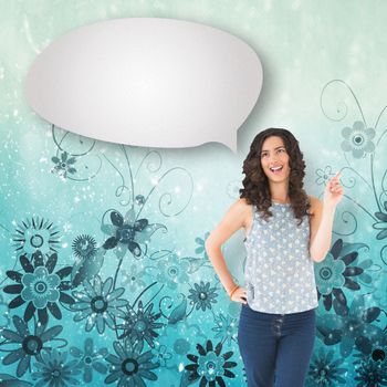 Happy beautiful brunette posing with speech bubble against digitally generated girly floral design