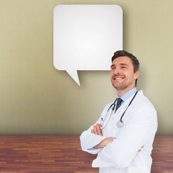 Handsome young doctor with arms crossed against speech bubble