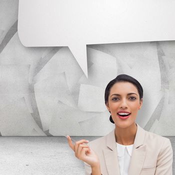 Smiling businesswoman holding a pen against speech bubble