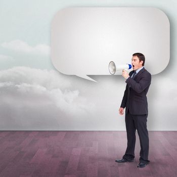 Standing businessman shouting through a megaphone with speech bubble against clouds in a room