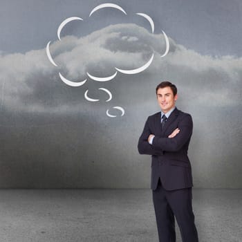 Young businessman standing cross-armed with speech bubble against clouds in a room