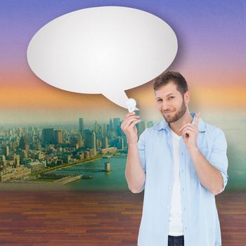 Charming model with speech bubble holding a bulb in right hand against city projection on wall