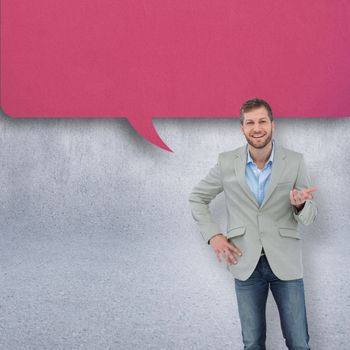 Stylish man smiling and gesturing against grey wall with speech bubble