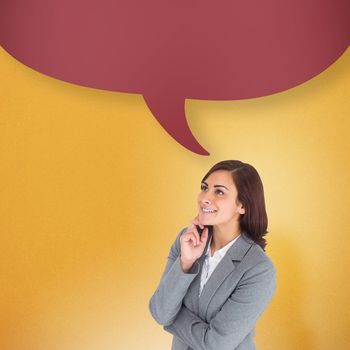 Smiling thoughtful businesswoman with speech bubble against yellow background with vignette