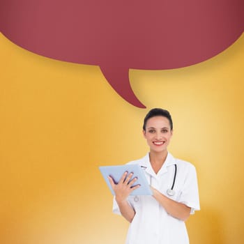 Pretty nurse using tablet pc with speech bubble against yellow background with vignette