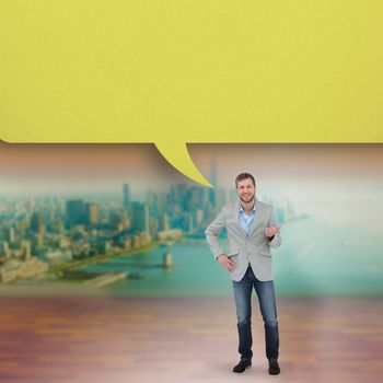 Stylish man smiling and gesturing with speech bubble against city projection on wall