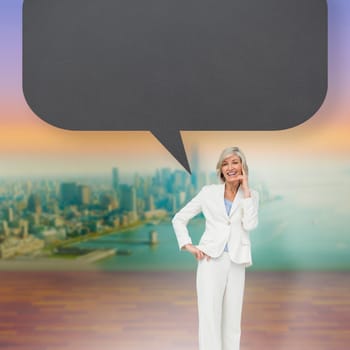 Thinking businesswoman with speech bubble against city projection on wall