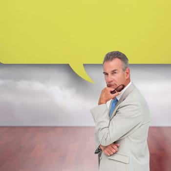 Thinking businessman with speech bubble against clouds in a room