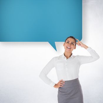 Smiling thoughtful businesswoman with speech bubble against white wall