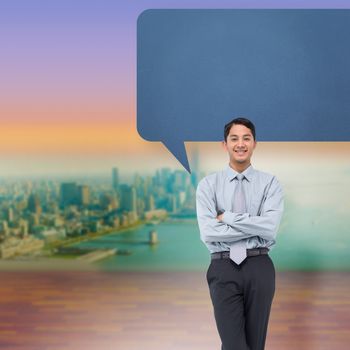 Smiling asian businessman with speech bubble against city projection on wall