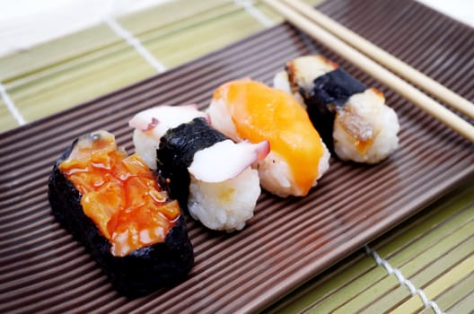 Sushi nigiri in with dish with bamboo sticks 