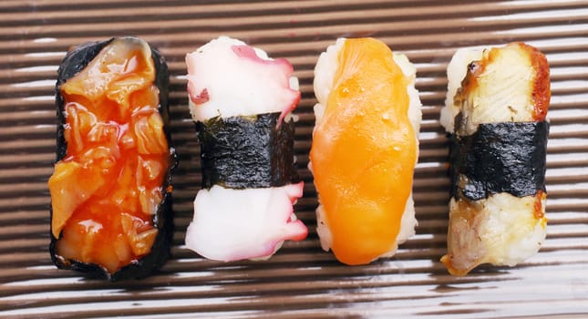 Sushi nigiri in with dish with bamboo sticks 