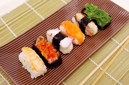Sushi nigiri in with dish with bamboo sticks