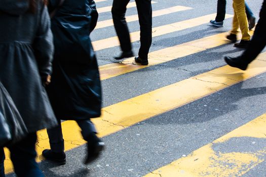 urban traffic concept - city street with a motion blurred crowd crossing a road