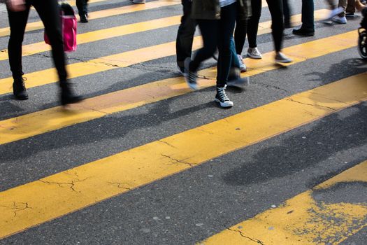 urban traffic concept - city street with a motion blurred crowd crossing a road