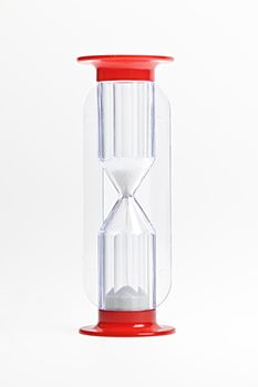 Hourglass of glass and red plastic isolated on white background