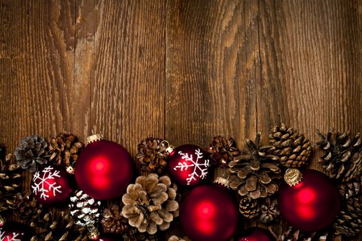 Rustic wood background with Christmas ornaments and pine cones