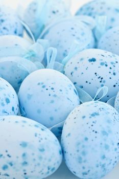 Pale blue speckled painted Easter eggs with ribbons