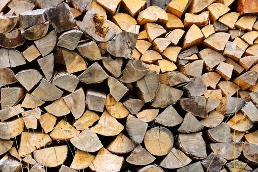 Background of chopped and split firewood logs stacked