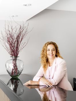 Receptionist standing at reception counter in office