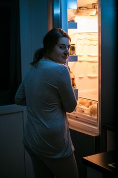 Closeup photo of woman looking in fridge at late night