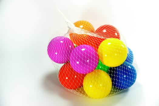 vivid plastic balls in white net sac on white scene,shallow focus