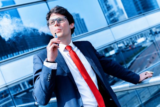 Cute young adult man inhaling from an electronic cigarette