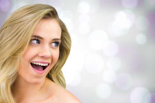 Smiling blonde natural beauty against purple abstract light spot design